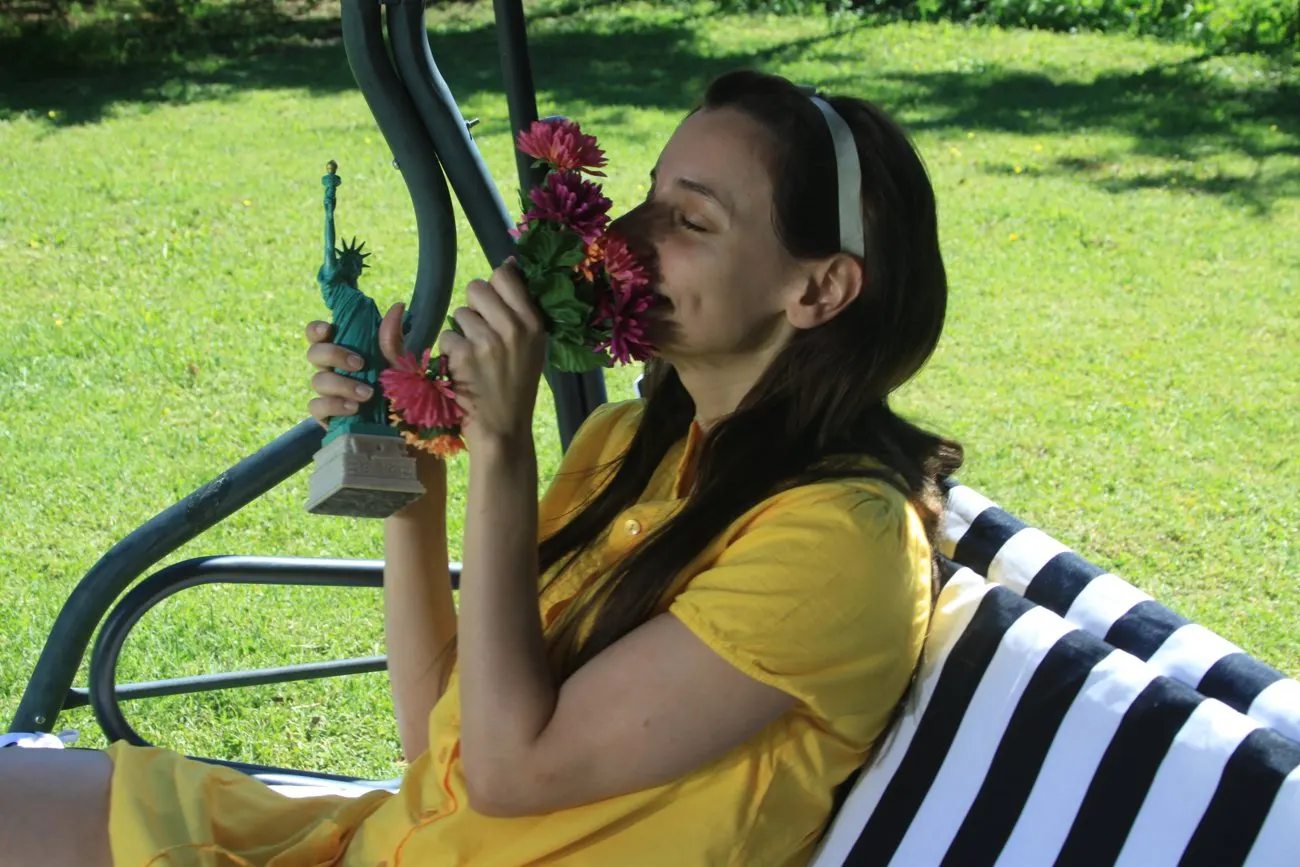 Fotografía de un personaje de El pozo sentado en un jardín.